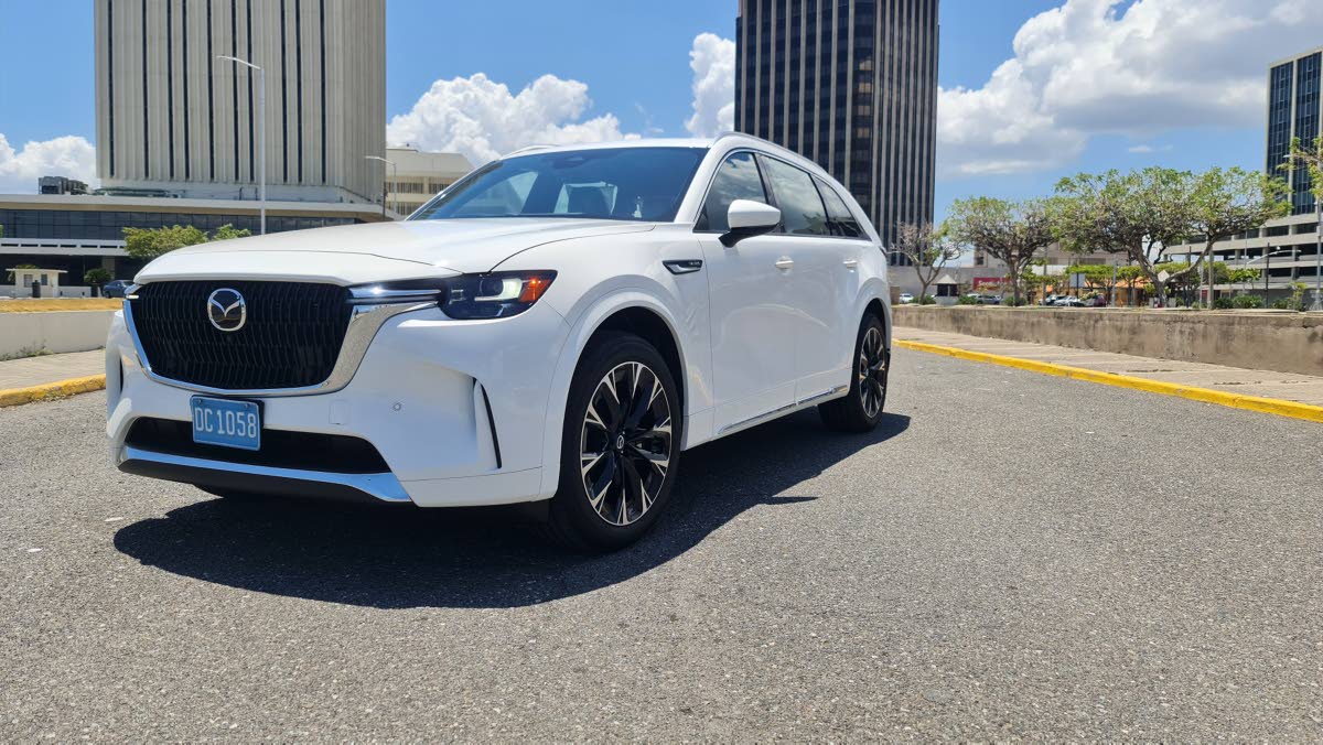 The Mazda CX-90 showcases its sculpted lines as they confidently meet the road, hinting at the dynamic driving experience that awaits.