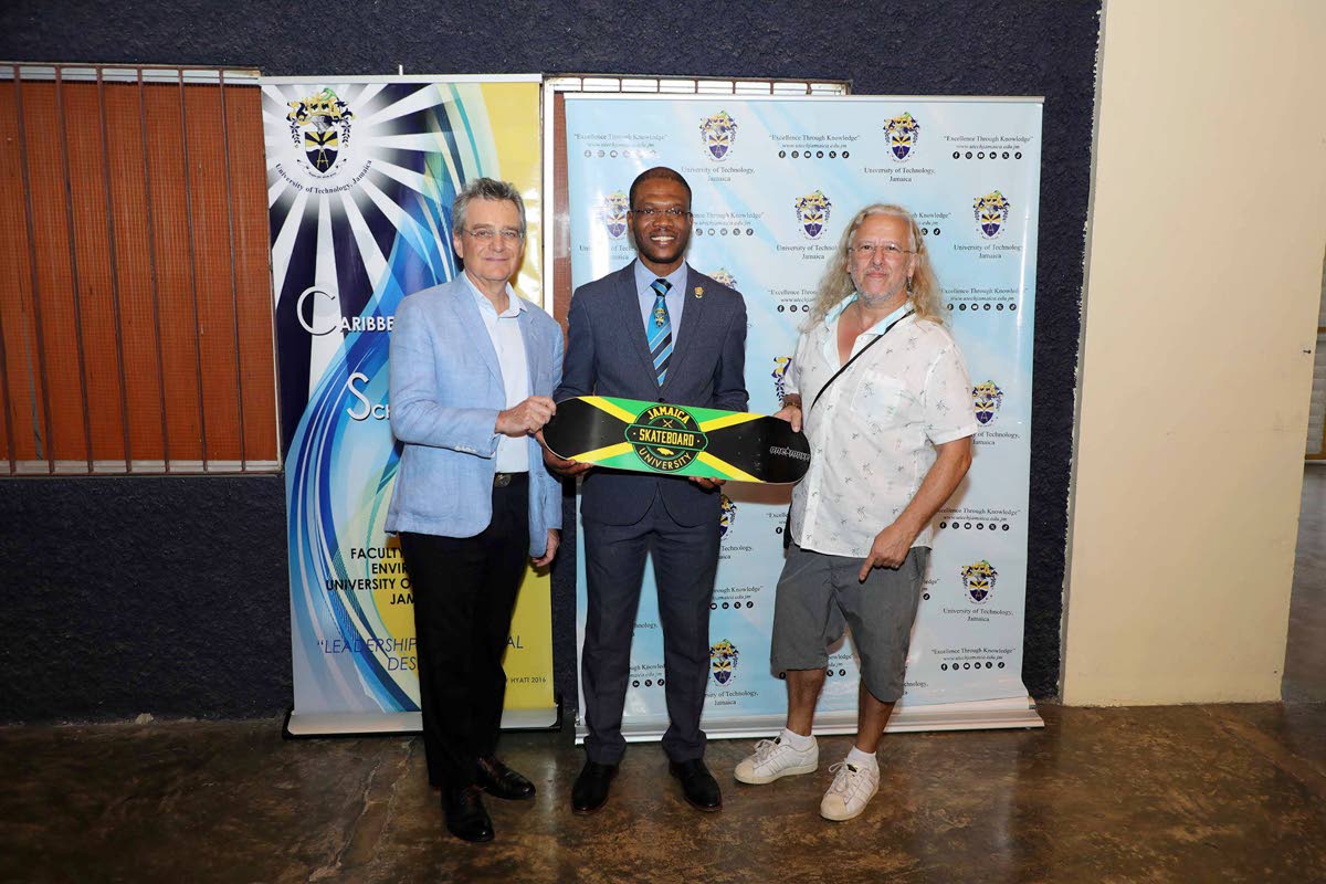 Remy Walter (right), founder, Jamaica Skate Culture Foundation, presents Dr Kevin Brown (centre), president, University of Technology, Jamaica, with a Skate Culture branded skateboard on August 7, inside the Alfred Sangster Auditorium. Participating in the