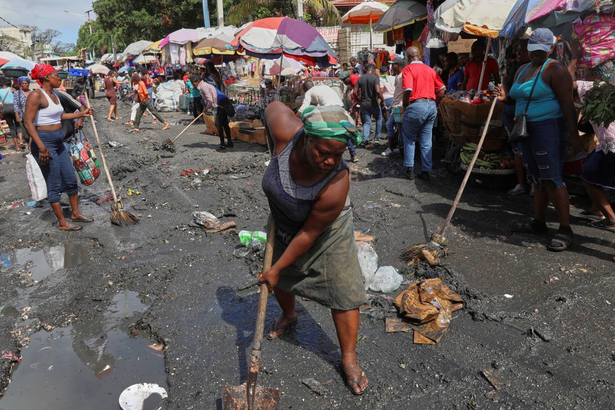 Vendors clean a street before starting to sell their goods in the Petion-ville neighbourhood of Port-au-Prince, Haiti.