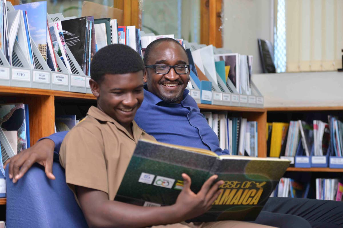 Fifteen-year-old Joshuah Channer of Wolmers Boys’ School, who aced three Caribbean Secondary Education Certificate subjects in fourth form, and dad Dr Guyan Channer.