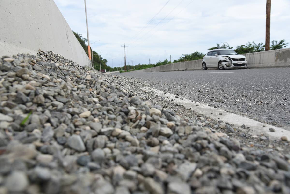 A car left disabled near Grants Pen, St Thomas, after it crashed in the barrier after skidding in gravel left along the roadway by trucks transporting aggregate.