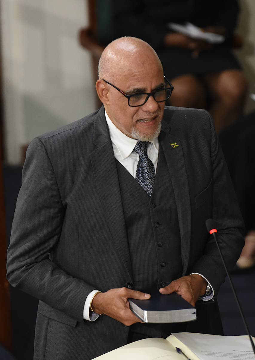 Keith Duncan takes the oath of allegiance during his swearing-in as a government senator in Gordon House on Thursday.