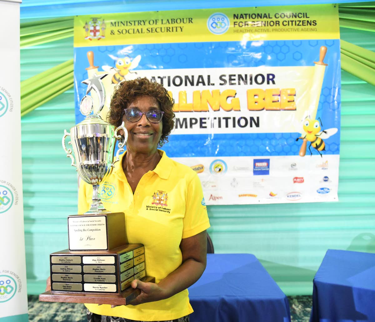 Champion speller Beverly Been happily poses with the winner’s trophy.