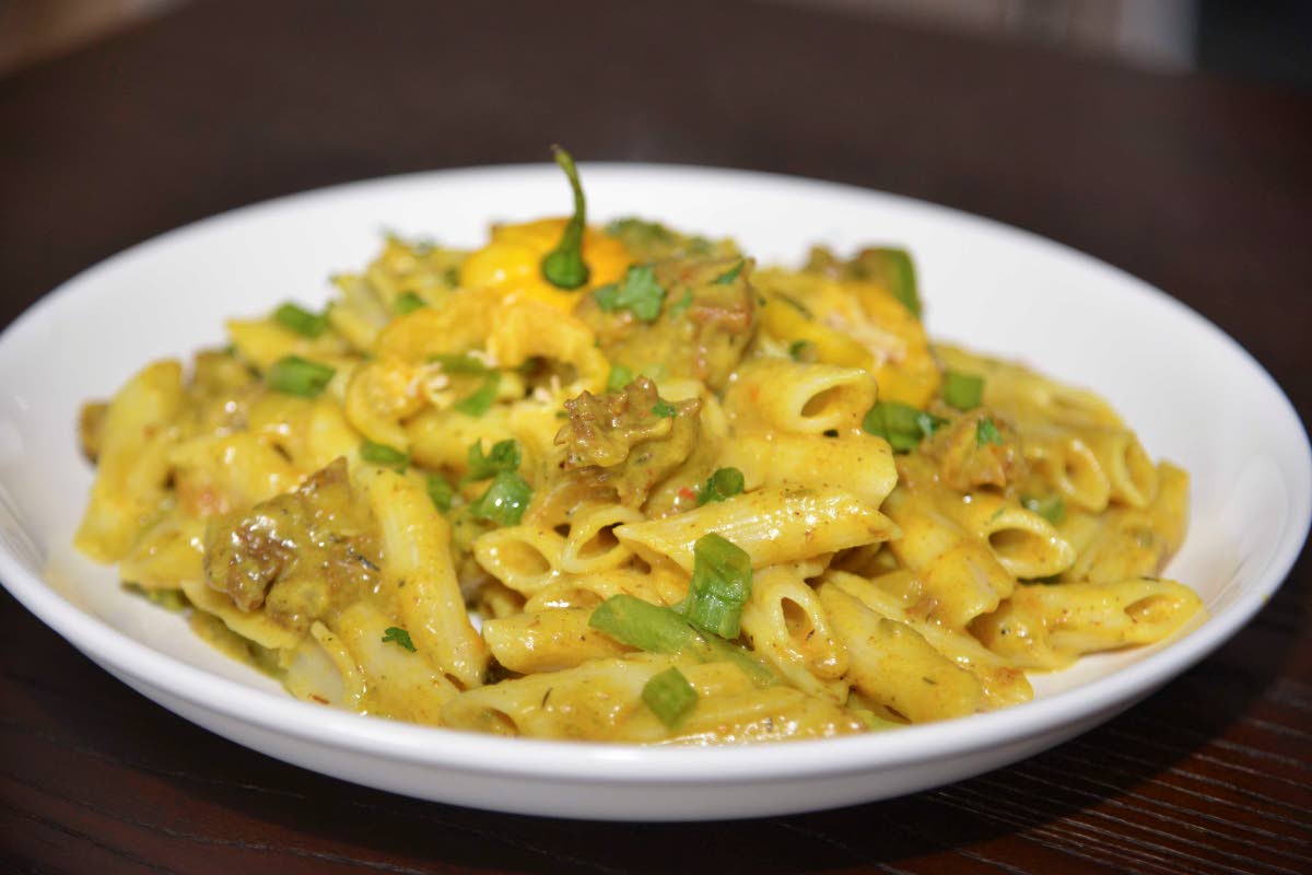 The curry goat pasta at Azi’s Pasta Plates offers a bold fusion, marrying slow-cooked Jamaican curried goat over fresh pasta.