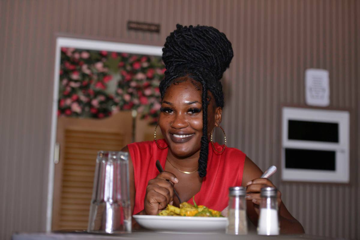 Kayodeen Edwards enjoys a serving of authentic Jamaican curried goat pasta at Azi’s Pasta Plates.