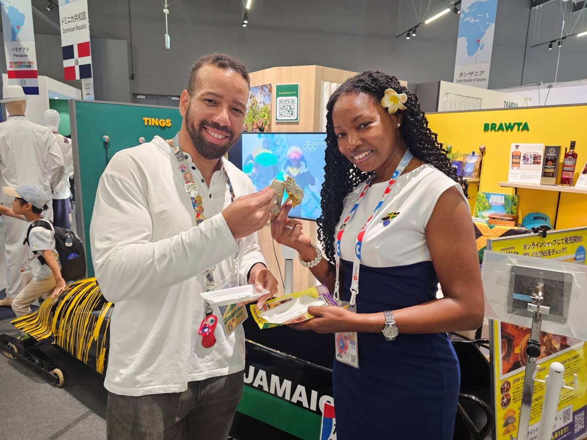 Commissioner General of Section, Jamaica Pavilion at Expo 2025 Osaka, Maureen Smith, and Jamaica Pavilion Director, Kevin Burke, about to take a bite of the Jamaican cheese patty presented by Gangalee Kitchen, at the Jamaica Pavilion, on October 7. 