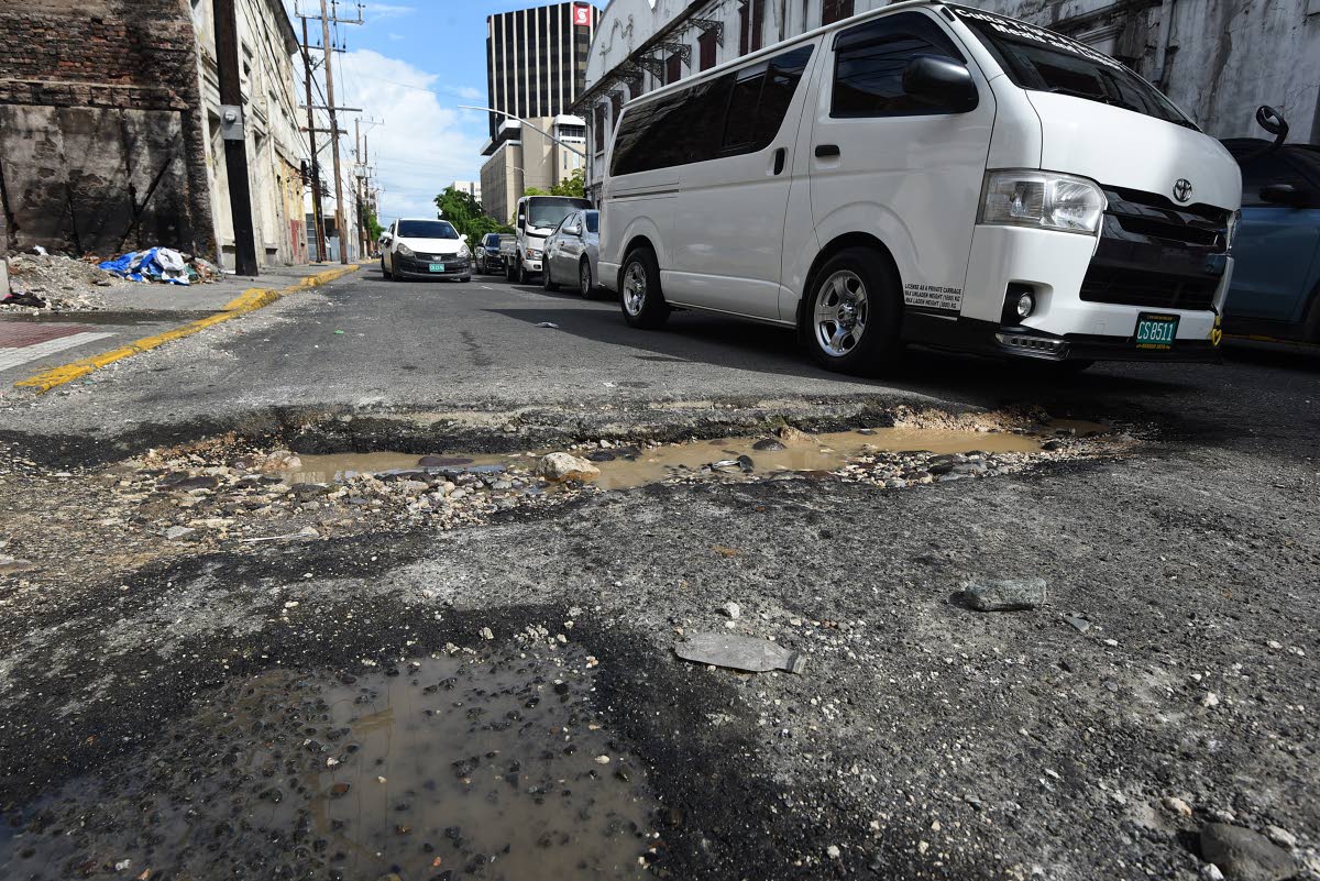 A large pothole stretches across Harbour Street in downtown Kingston, forcing motorists to abandon two of the three lanes to avoid falling in. The pothole has been there for more than six months and has got wider during recent rains. 