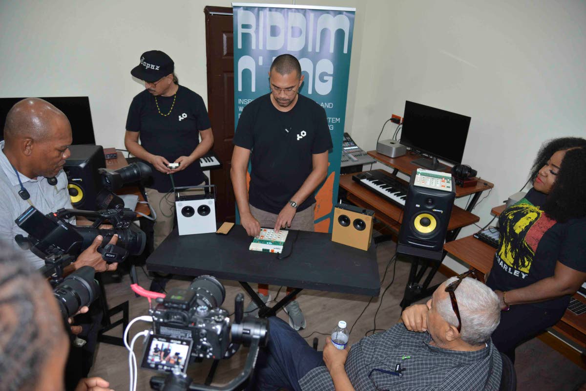 Marcus Price (centre) explains how to use the EP-40 drum machine to the attendees at Teenage Engineering presentation at Alpha Boys’ School on Monday. At right is singer Etana, and beside her, seated, is veteran producer and sound system man, King Jammy.