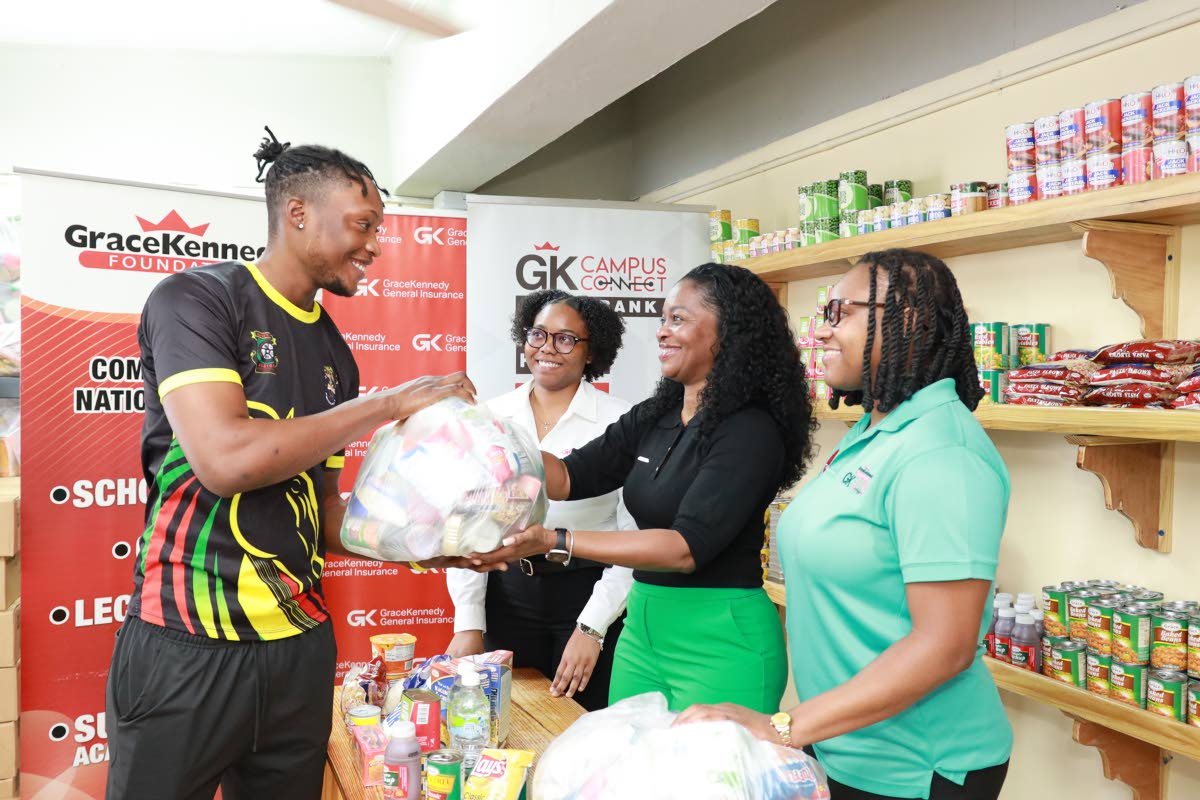 Gavaine Bailey (left), second-year computer science major at the University of Technology, Jamaica, receives the first package for the 2025/2026 academic year from the GK Campus Connect Food Bank. Also pictured are (from second left) Jayde Noel-Sailsman, G