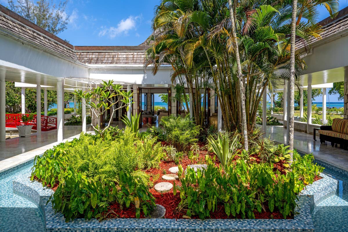 An open-air atrium in the centre of the structures, filled with flowing cascading water, palms and shrubbery. Amazing!