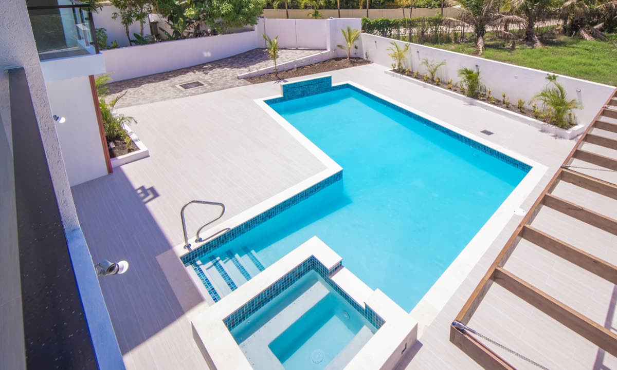 The pool is highlighted by a waterfall feature and its hot tub.