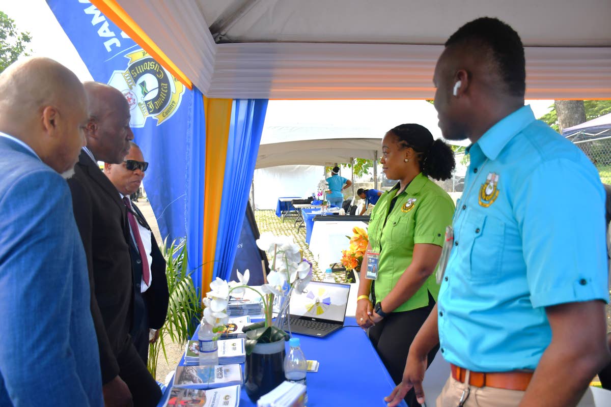 Chief Justice Bryan Sykes (second left), surrounded by his team, tries his luck at JCA’s Spin the Wheel while JCA Legal Officer Trichana Gray Nicholson (second right), and System Administrator Brenton Clarke (first right), wait to see how lucky he would 