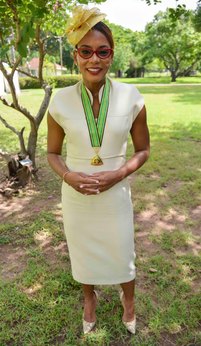 Veteran journalist Emily Shields, newly conferred with the Order of Distinction in the Commander class, completes a classic look with a gold fascinator.