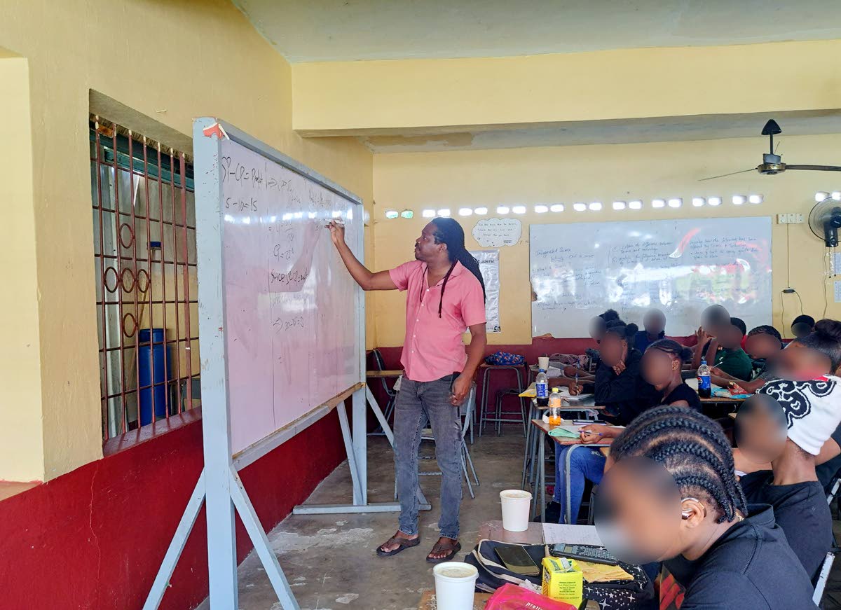 Damion Crawford, member of parliament for St Catherine North Western, goes through a math equation during one of the math classes at Charlemont High School in Linstead, St Catherine on October 18.