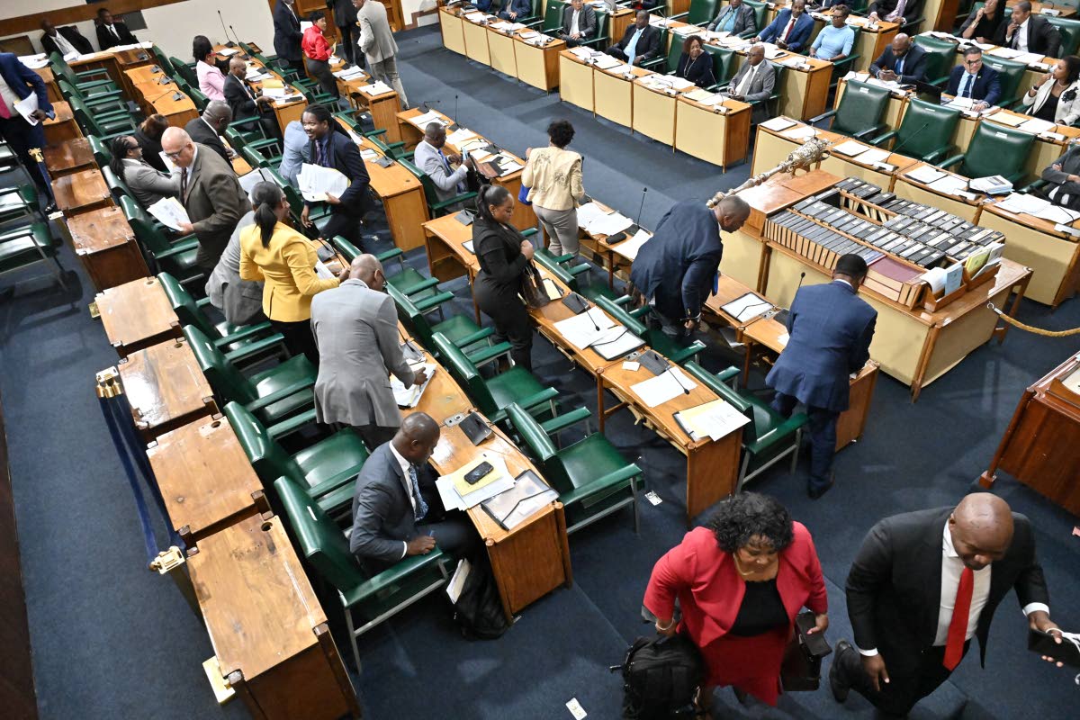 Members of the parliamentary Opposition gather their belongings as they walked out of Gordon House on Tuesday in protest after House Speaker cut Opposition Leader Mark Golding’s microphone.