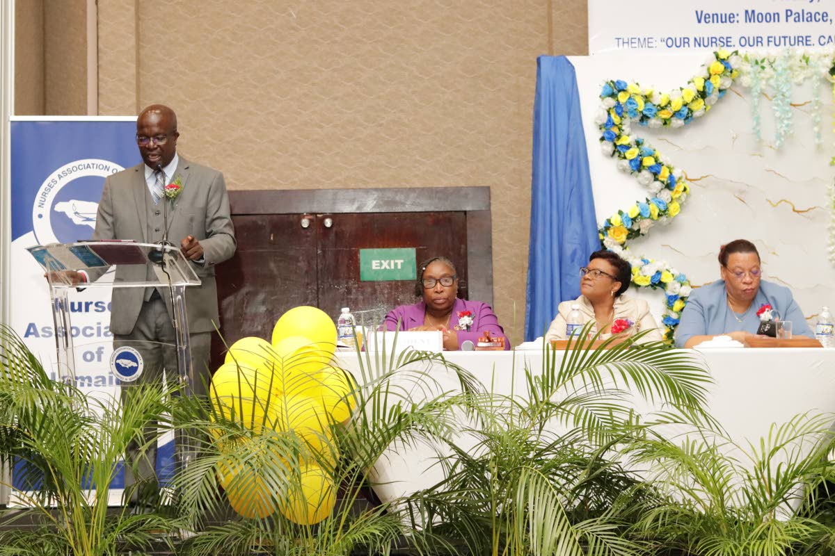 Delroy Williams (left), principal of Iona High, delivers the keynote address at the Nurses Association of Jamaica’s (NAJ’s) 55th Island Conference at the Moon Palace Hotel in Ocho Rios, St Ann, recently. Listening on are (from left): Dawn Marie Richard