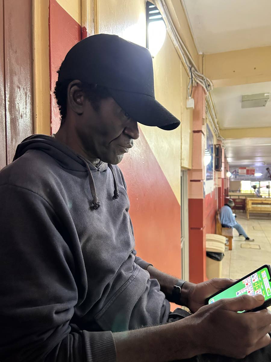 A stranded Rupert Roach sits on a bench at the Mandeville Regional Hospital, where he will have to wait out the hurricane before returning home.