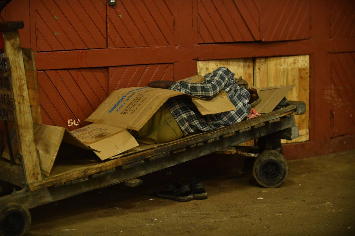 Higglers and hustlers find their areas to sleep in the safety of the Coronation Market as Hurricane Melissa approaches the island yesterday.