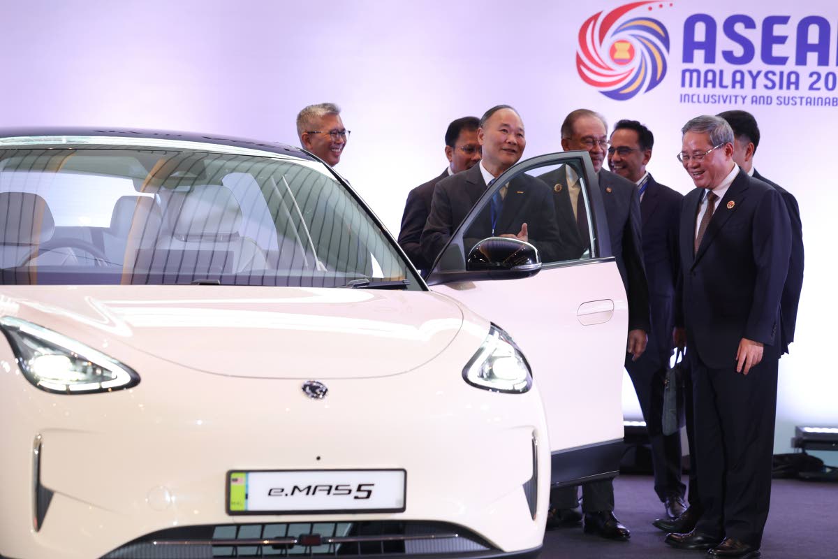 Chinese Premier Li Qiang (right) reacts as he, along with Malaysian Prime Minister Anwar Ibrahim (centre) inspects a car produced by Malaysia’s national automaker, Proton, in which China’s Zhejiang Geely Holding Group holds a 49.9 per cent stake, ahead