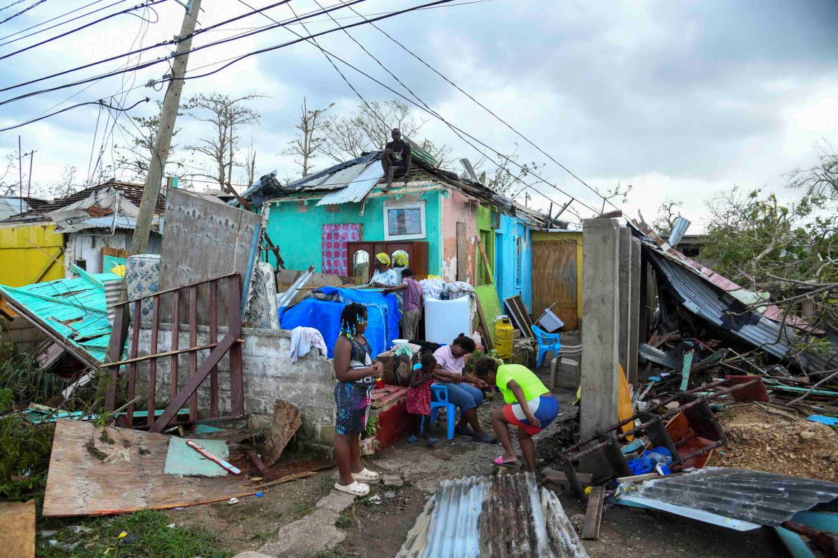 Residents of Cornwall Street in Falmouth, Trelawny, look at the damage done to their homes and possessions after the passage of Hurricane Melissa, which swept through the island on Tuesday.