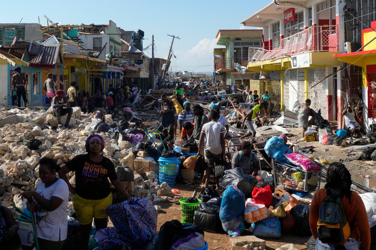 Residents gather amid debris in the aftermath of Hurricane Melissa on a street in Black River, Jamaica.