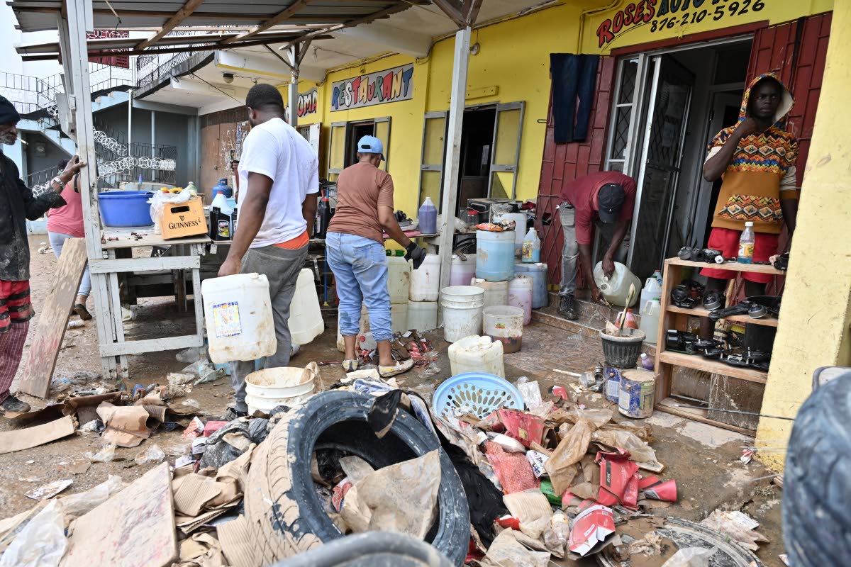 Annmarie Rose, owner of an auto parts store in Cave Valley, St Ann, cleaning her shop after Hurricane Melissa caused damage.