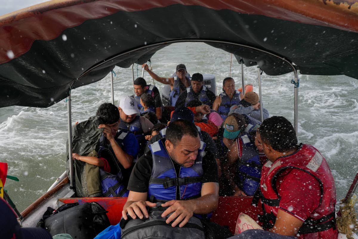 Luis Sanchez (centre) sits with other Venezuelan migrants on a boat leaving Gardi Sugdub on Panama’s Caribbean coast.