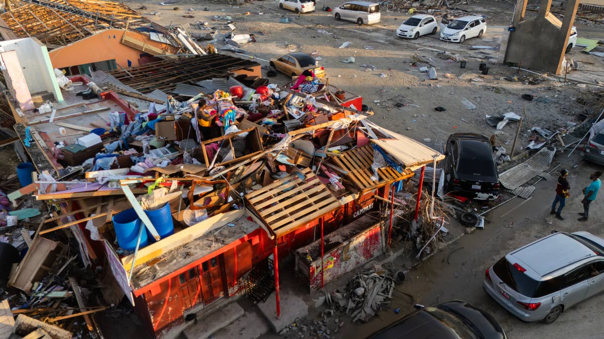 A woman is seen in what would be the second storey of a building, sorting through personal effects on North Street in Black River, St Elizabeth. 
