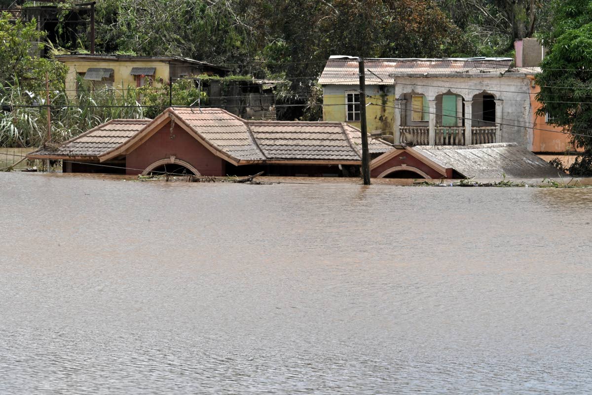 A flooded-out home, with water up to its roof, in Cave Valley, St Ann last week. 