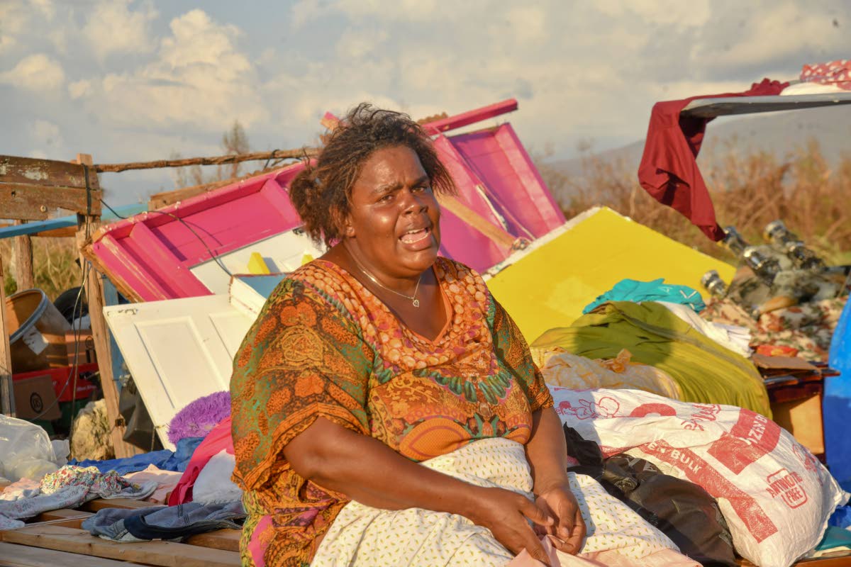 Nicola Gowdie sits in tears among the remains of her house on Crane Road, St Elizabeth, on October 30.