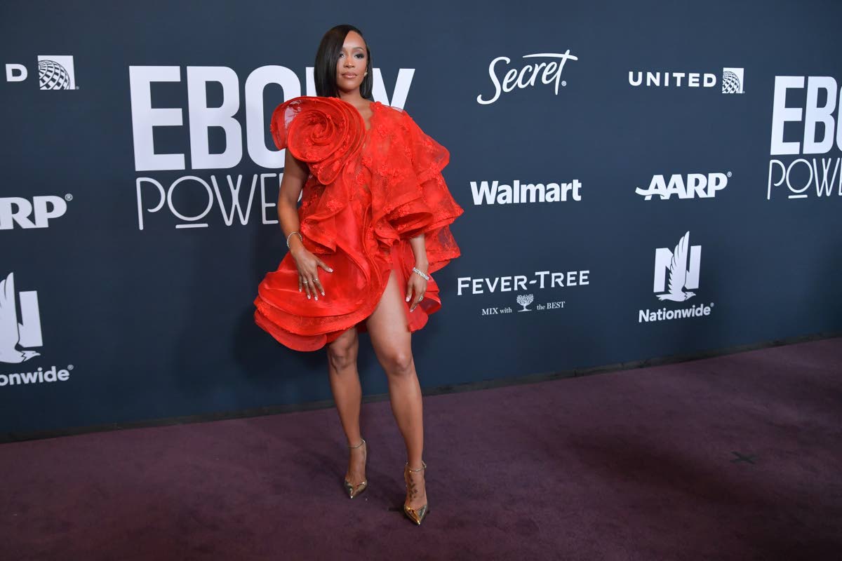 Amanda Booz wears a vibrant red, floral bouffant-type mini dress. 