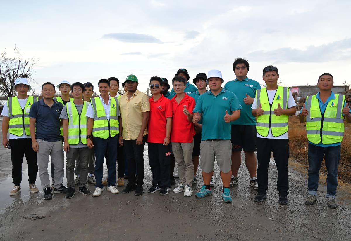 Members of the Chinese community out of western Jamacia with Floyd Green, member of parliament for St Elizabeth South Western, during a visit on Wednesday to Parottee in St Elizabeth, one of the areas hit hardest by Hurricane Melissa