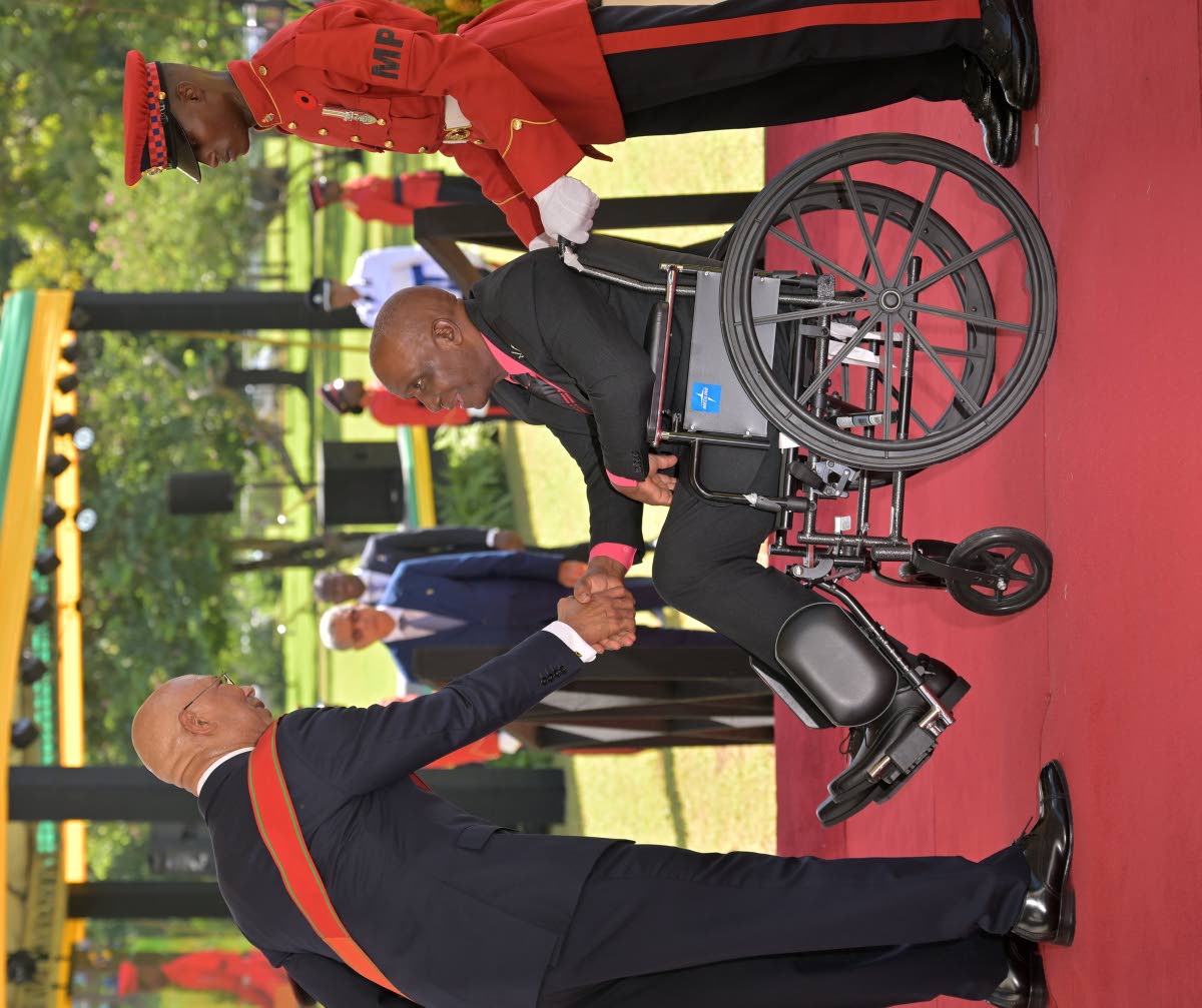 Governor-General Sir Patrick Allen (left), greets Former Commissioner of the Jamaica Fire Brigade, Errol Mowatt (centre), before conferring him with the Order of Distinction in the rank of Officer on October 20, during the Ceremony of Investiture and Prese