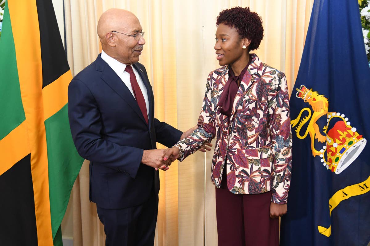 Governor General Sir Patrick Allen (left) congratulates Tiana Dinham after she was named the 2026 Rhodes Scholar on Thursday.