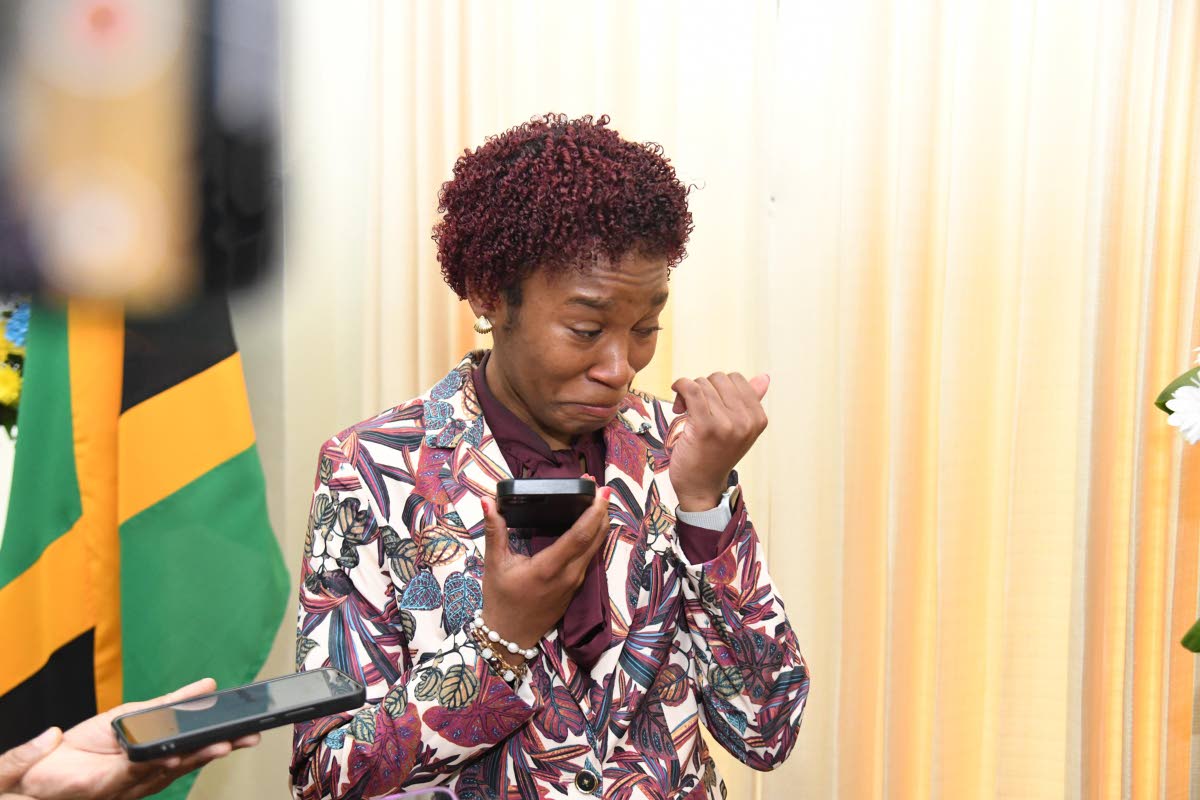 Tiana Dinham, the 2026 Rhodes Scholar, gets emotional as she breaks the news to her mom via phone shortly after she was announced as the scholarship recipient at King’s House in St Andrew on Thursday.