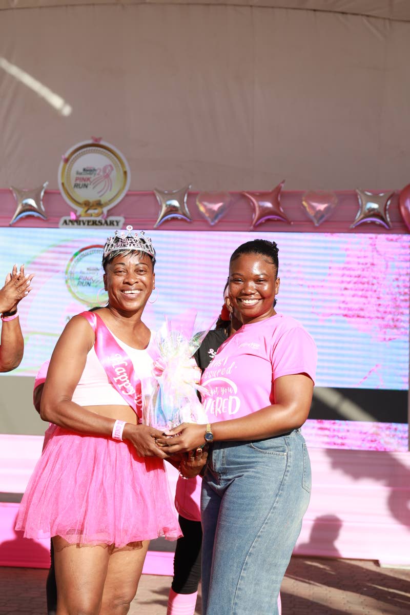 A happy Marlene Dawson (left) receives a gift from Daniela Fagon, finance professional, at the 25th anniversary staging of Jamaica Reach to Recovery’s 5K Pink Run on Sunday at Emancipation Park in New Kingston.