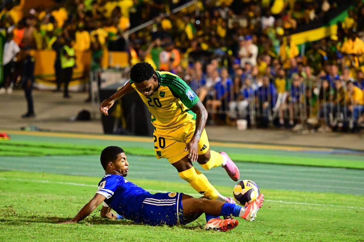 Curaçao’s Shurandy Sambo (left) tackles Reggae Boyz Renaldo Cephas.