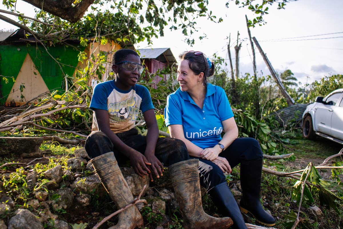 Olga Isaza (right), representative, UNICEF Jamaica, talks with 12-year-old Antwane from Rocky Hill, St Elizabeth about the impact of Hurricane Melissa.