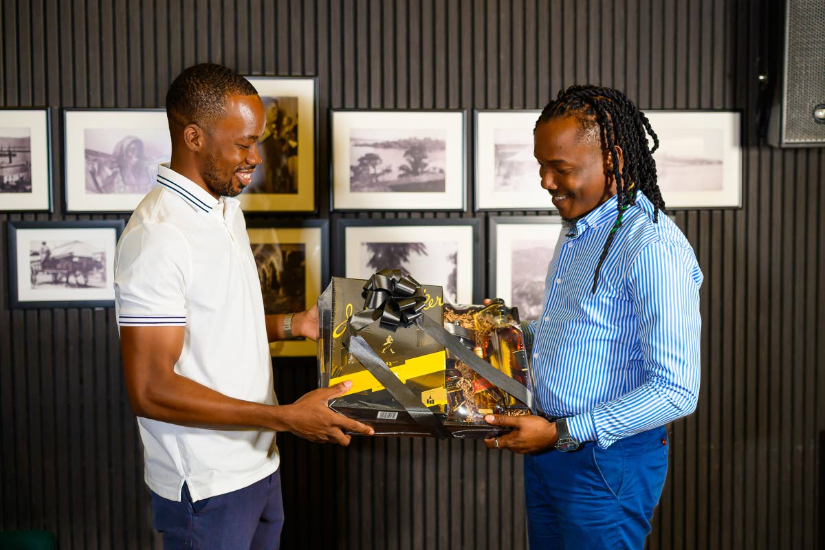 Johnnie Walker Junior Brand Manager Lasana Wilson (left) presents photographer Gerald Gordon with a special Johnnie Walker gift set, in recognition of his creative contribution and inspiring journey.