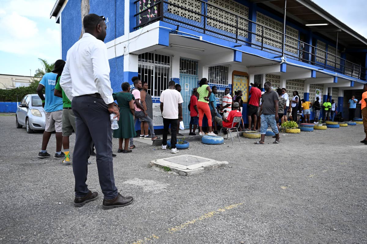 People are seen waiting outside a polling station at Morant Bay Primary School, St Thomas to cast their votes in September’s general election.