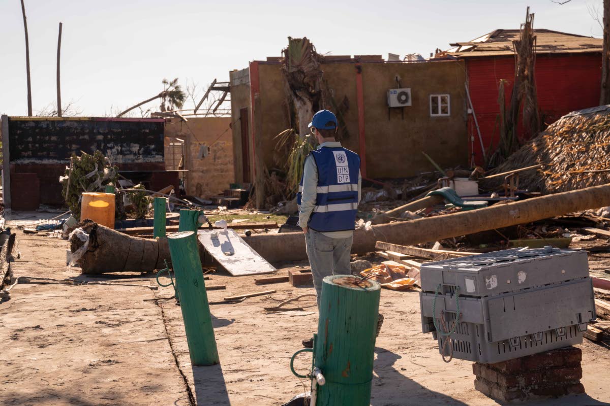 A UN representative surveys some of the damage from Hurricane Melissa.