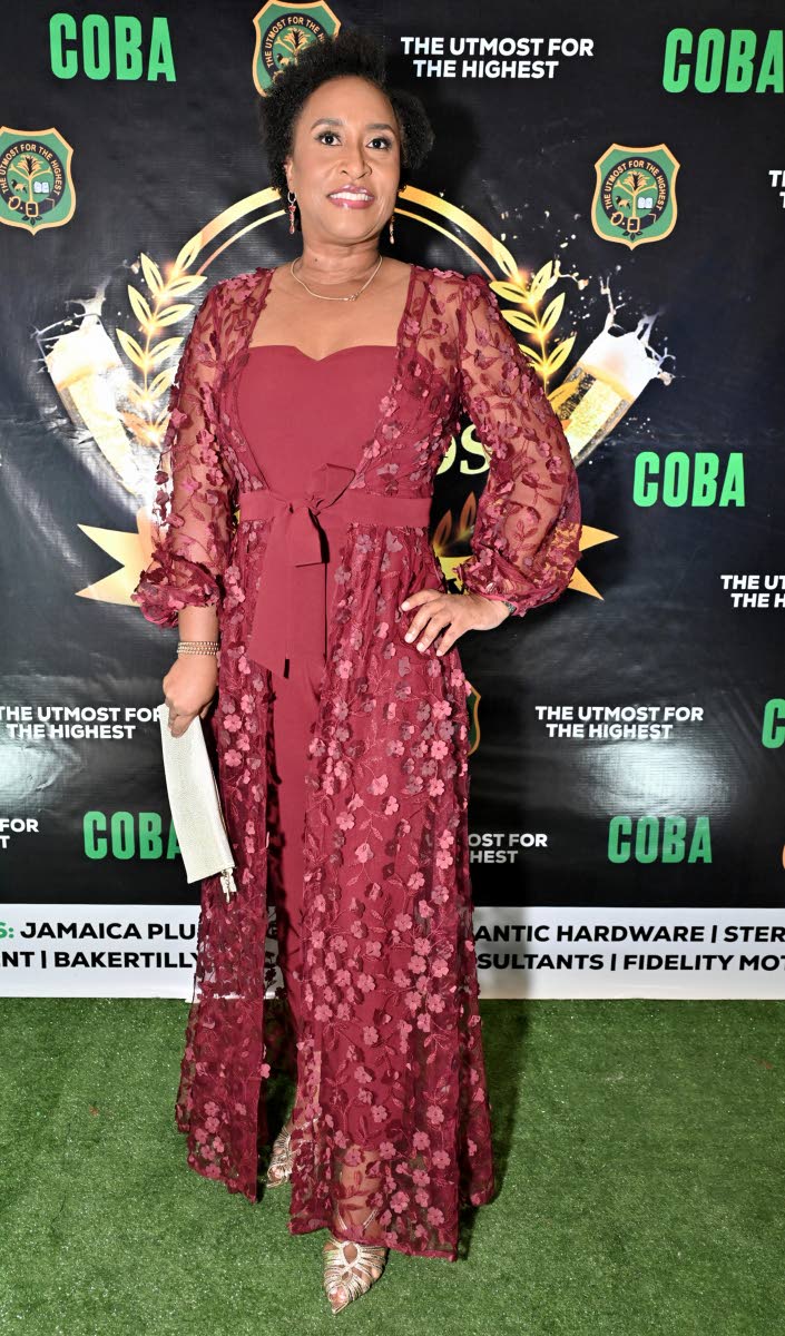 Simone Dunbar, public relations officer for the Westwood Old Girls Association, steps out in a deep red, floor-length lace dress with sheer sleeves and delicate floral detailing as she arrives at the Calabar Old Boys’ Association Cocktail Party and Award