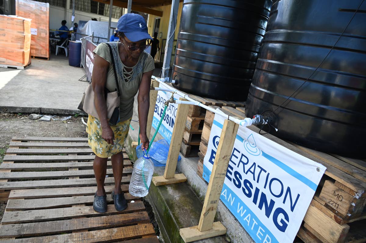 A Montego Bay resident collects water at the Operation Blessing headquarters on the Trumpet Call Ministries grounds in Montego Bay, St James.