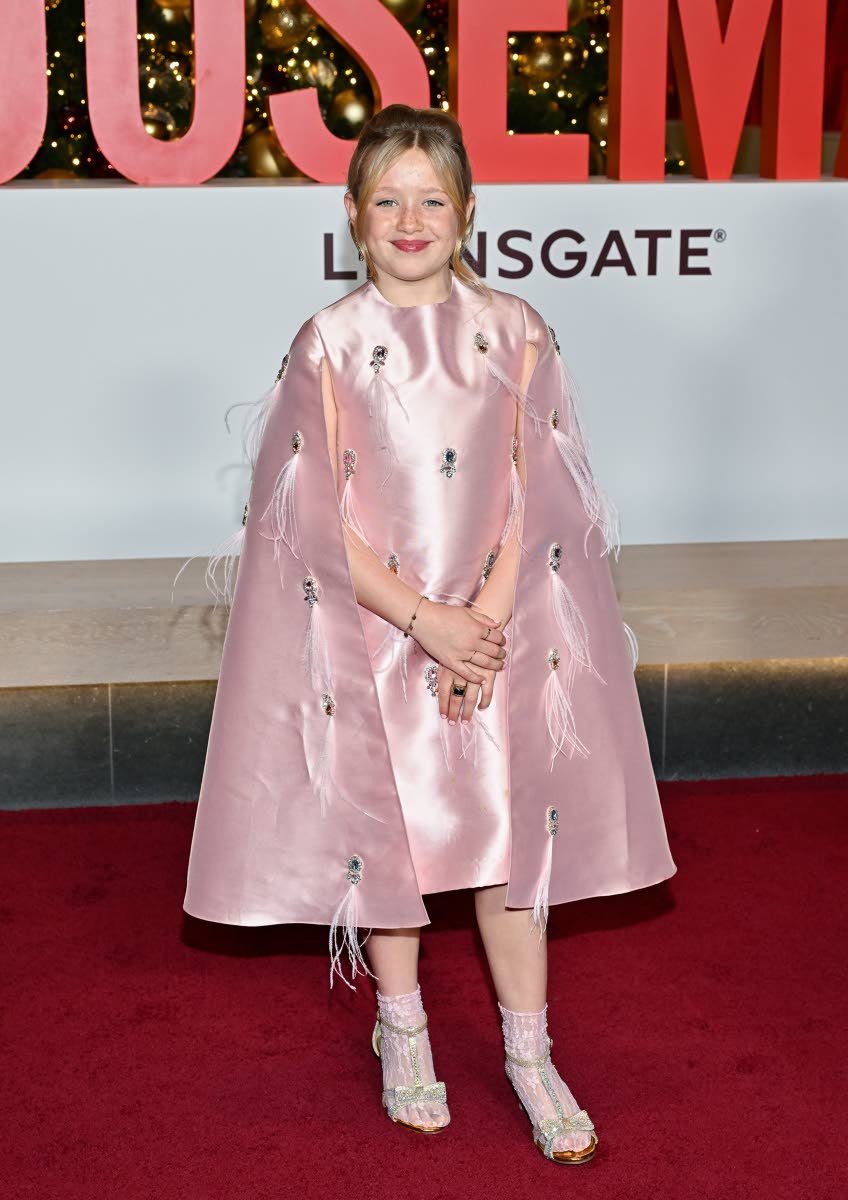 Indiana Elle in a blush Maison Ava Swarovski-embroidered cape dress, finished with delicate feather detailing.