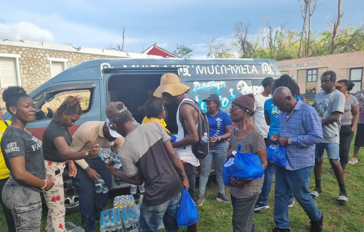 Residents of Chatham, St James, collect care packages and bottled water during the RG CARES outreach in St James on November 23, part of the foundation’s continuing relief efforts following Hurricane Melissa.