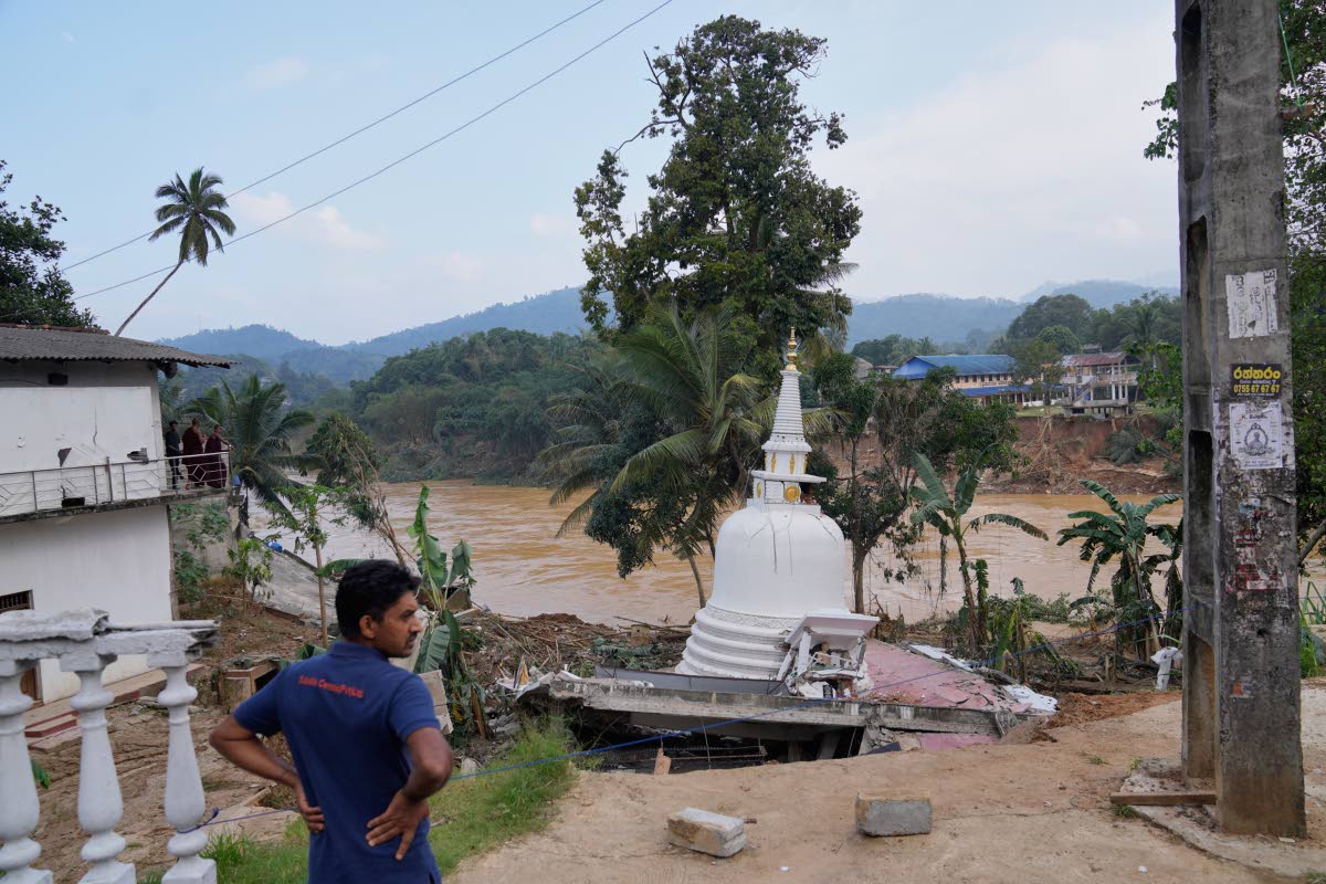 A man looks at the damage caused by the floods at Gampola, Sri Lanka.
