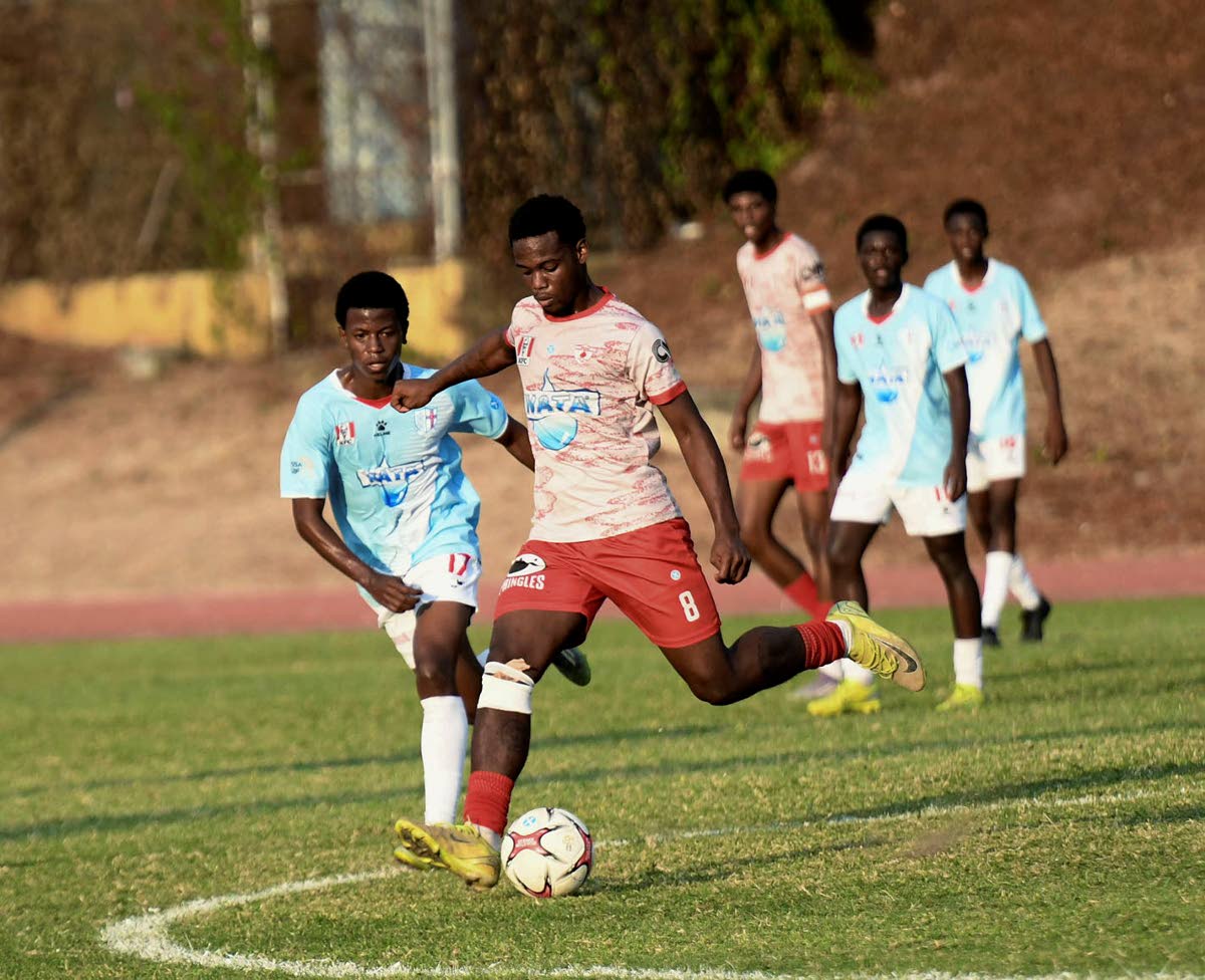 Javade Wallace of Mona High School (second left) looks to kick the ball as Malik Garriques of St George’s College reacts during the Walker Cup KO football match at Stadium East on December 10.