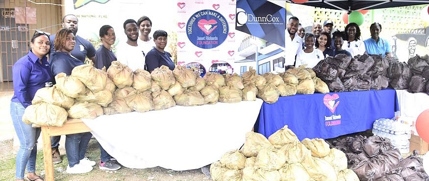 Janet Richards (right), founder of the Janet Richards Foundation, in a group shot with representatives from the Kingston-based law firm DunnCox during a handover of relief items to residents of Farm Heights, St James, last Thursday, following the passage o