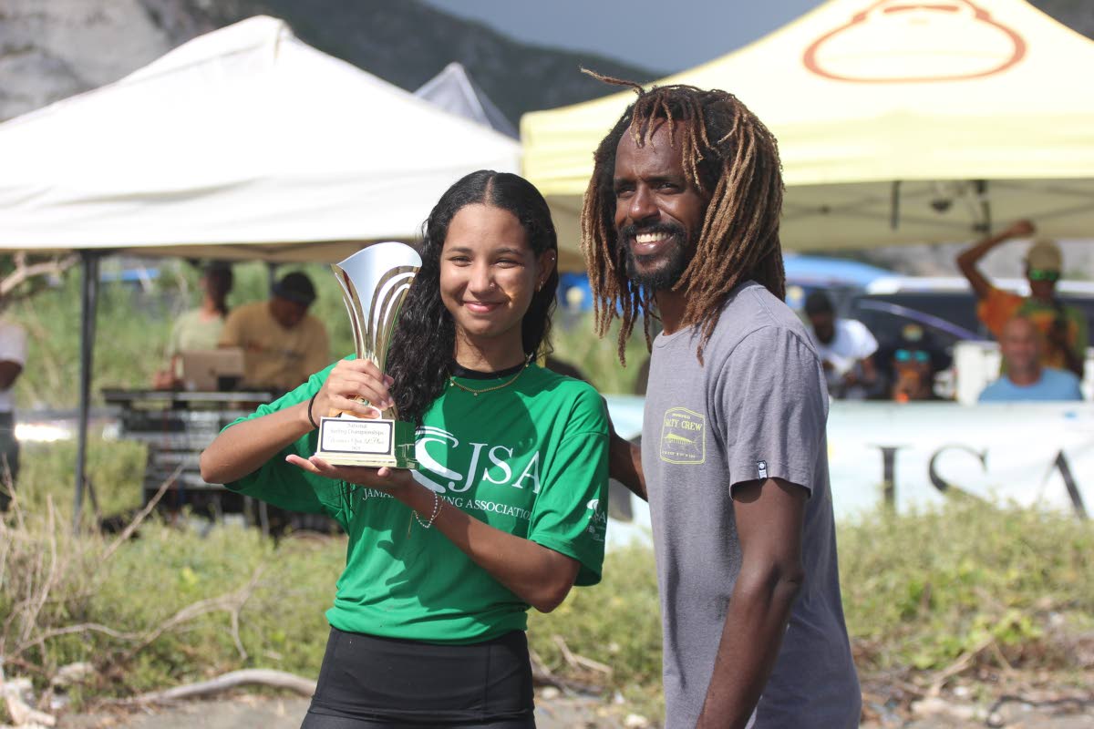 Aaliyah Alkateeb (left) receives a trophy for winning the National Surfing Championships title from Jamaica Surfing Association competitions co-ordinator, Icah Wilmot, at the Copa Beach on Sunday.