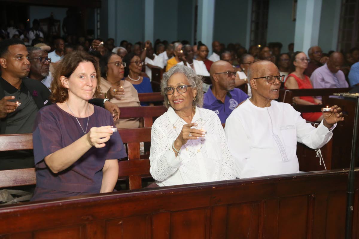 Sir Kenneth Hall, former governor general of Jamaica, is captured singing along to carols with his wife, Lady Rheima Claire Hall (centre), and French Ambassador to Jamaica, Marianne Ziss.